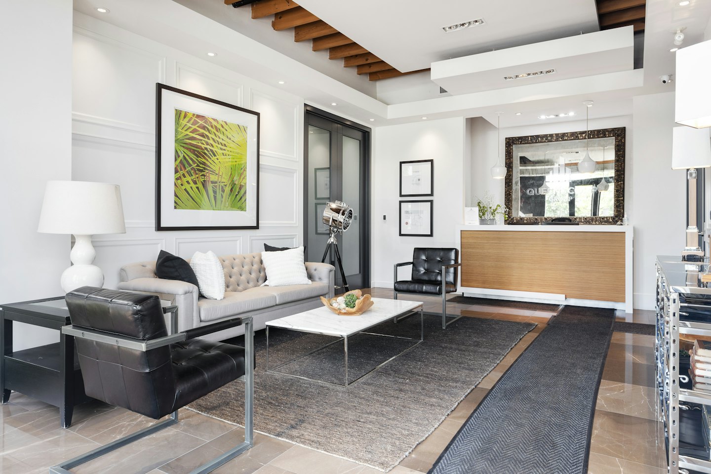 Modern office reception area with seating and a wooden desk.